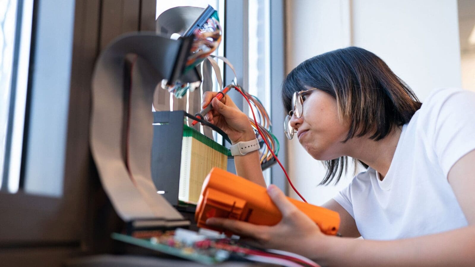 Researcher adjusting voltage on an electronic device